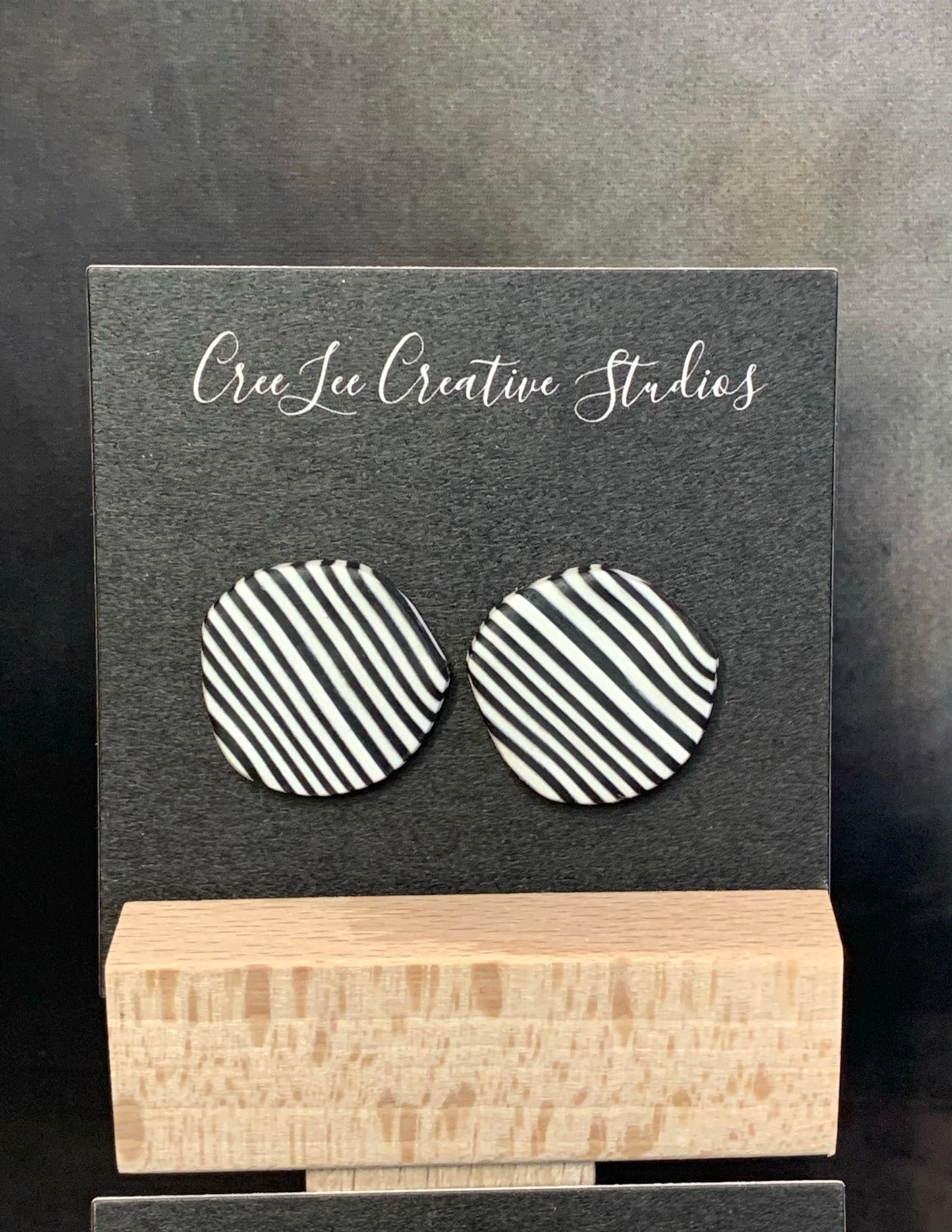 A pair of abstract circle studs in black and white stripes.