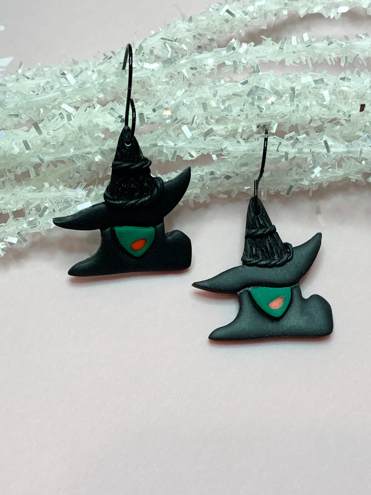 Earrings that look like Elphaba face and hat from the musical movie Wicked.