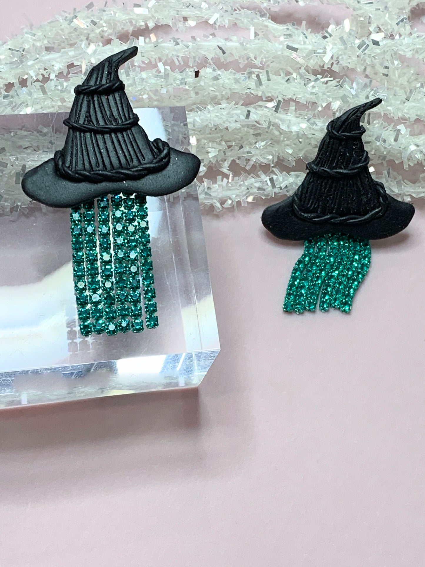 Matte black Elphabas hat with green rhinestones hanging from the hat brim.