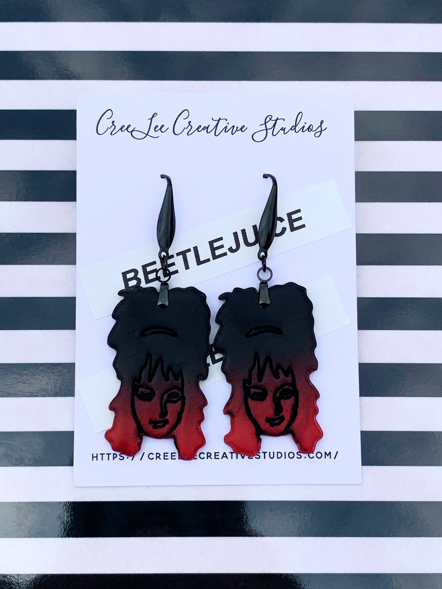 Ombre black to red earrings featuring Lydia Deetz on an earring card branded for CreeLee Creative Studios.