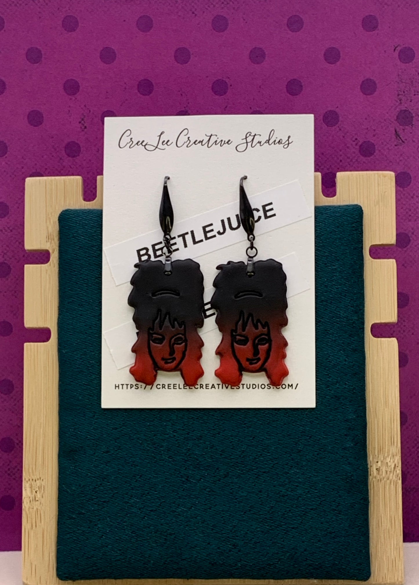 Ombre black to red earrings featuring Lydia Deetz on an earring card branded for CreeLee Creative Studios.