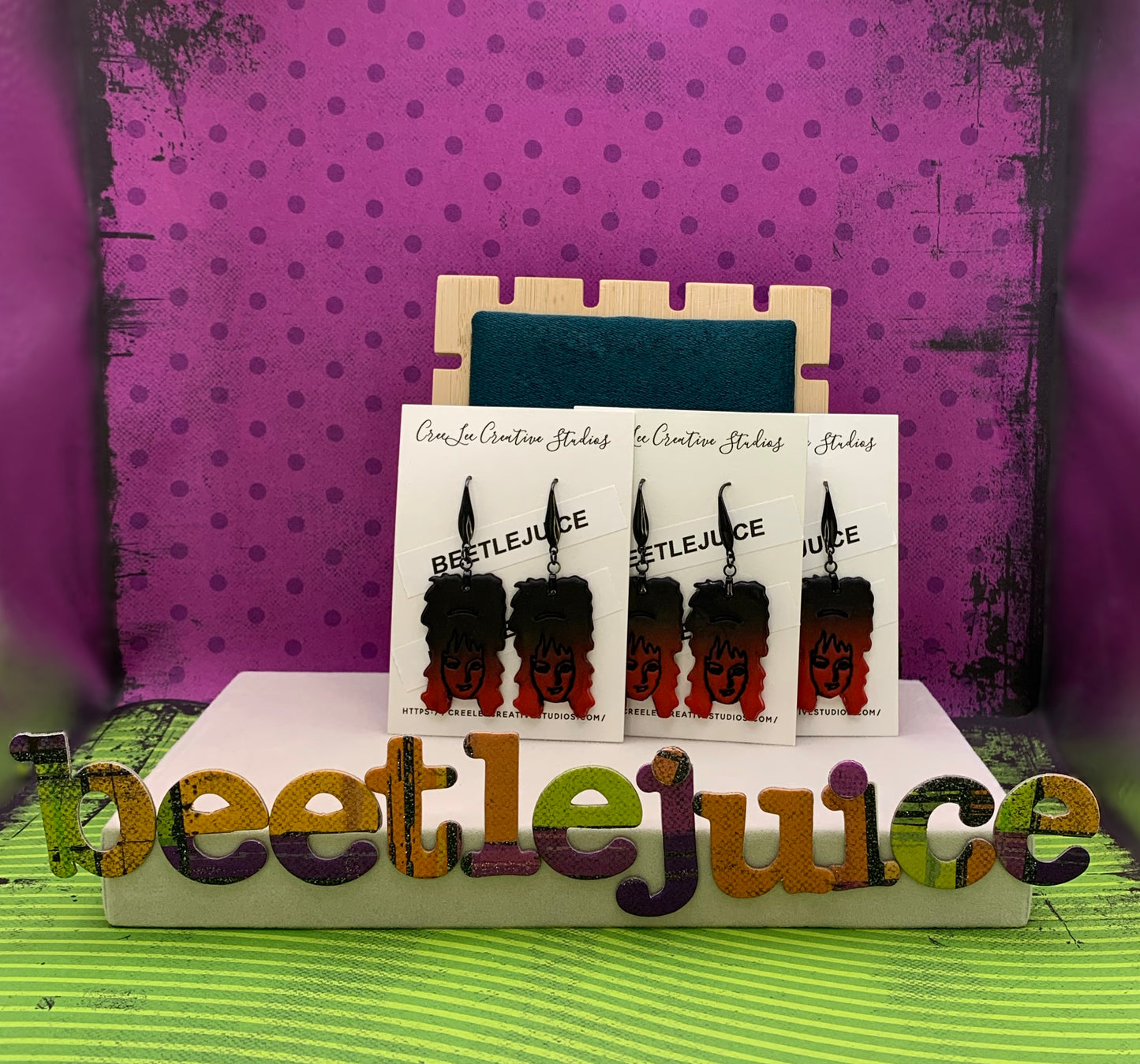 Ombre black to red earrings featuring Lydia Deetz on an earring card branded for CreeLee Creative Studios.