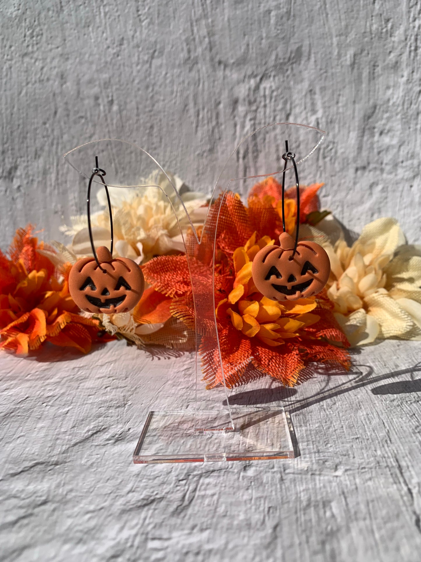 Orange jack-o-lantern earrings on black hoop