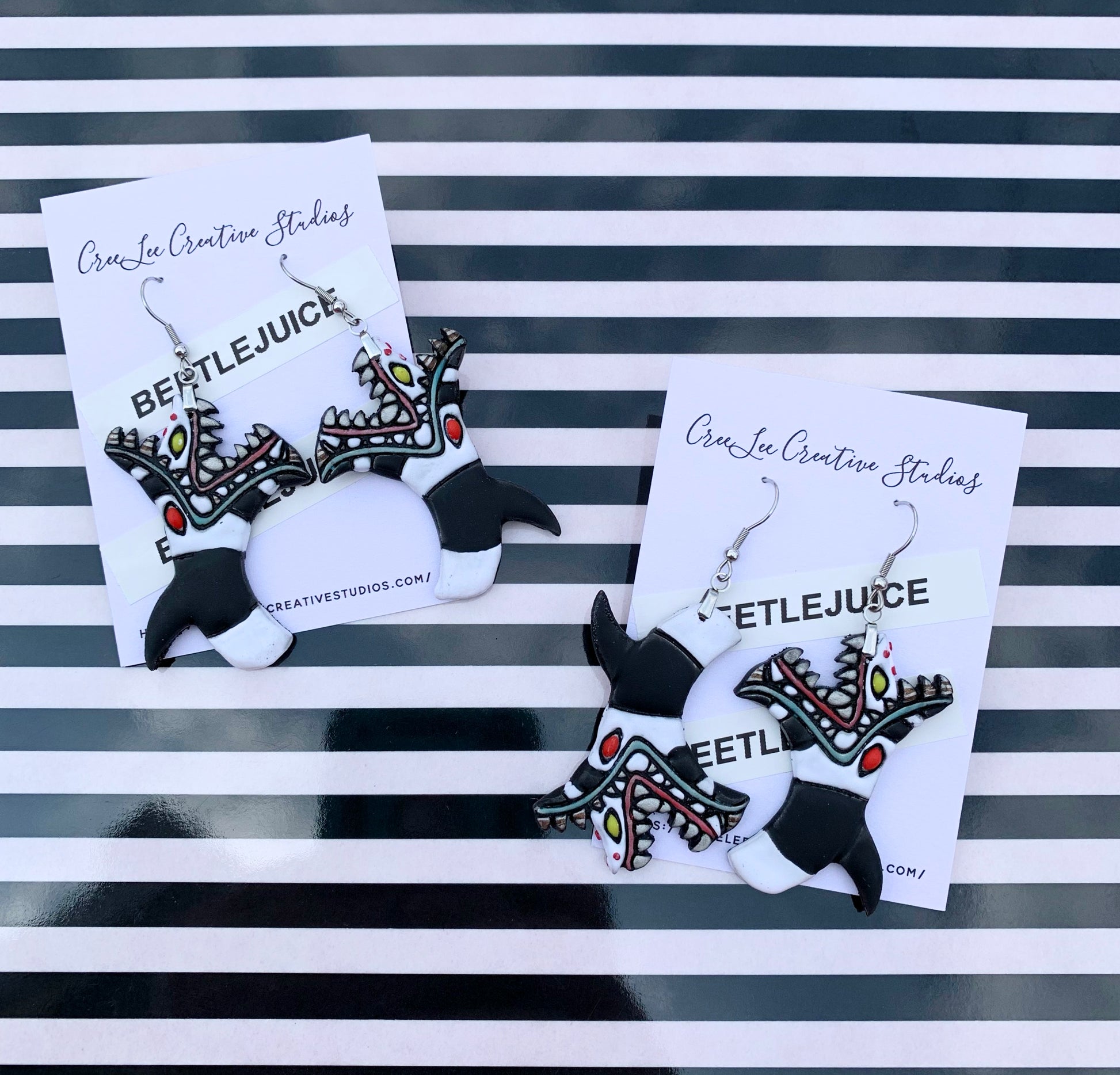 Sandworm from Beetlejuice handpainted on an earring card branded CreeLee Creative Studios.