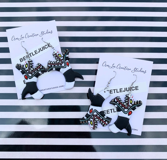 Sandworm from Beetlejuice handpainted on an earring card branded CreeLee Creative Studios.