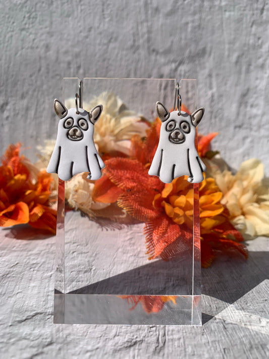 Handmade Dog Ghost Dangle Earrings — spooky-cute polymer clay earrings that pair pup-lover charm with Halloween whimsy. Each lightweight dangle features a white ghost-sheet silhouette with dog ears and delicate black-etched facial details, finished on silver-toned stainless steel fishhook findings for comfortable all-day wear. Perfect search terms: dog ghost earrings, Halloween dog jewelry, polymer clay dog earrings, spooky cute earrings, handmade Halloween earrings. 