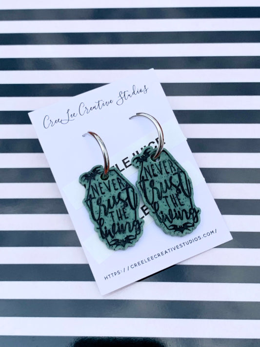 A pair of green, stone-like polymer clay earrings with black text, displayed on a card with 'CreeLee Creative Studios' branding.