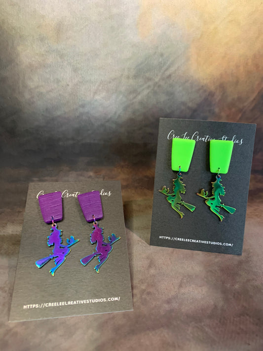 A pair of vibrant neon green or purple dangle earrings with a stainless steel witch charm.