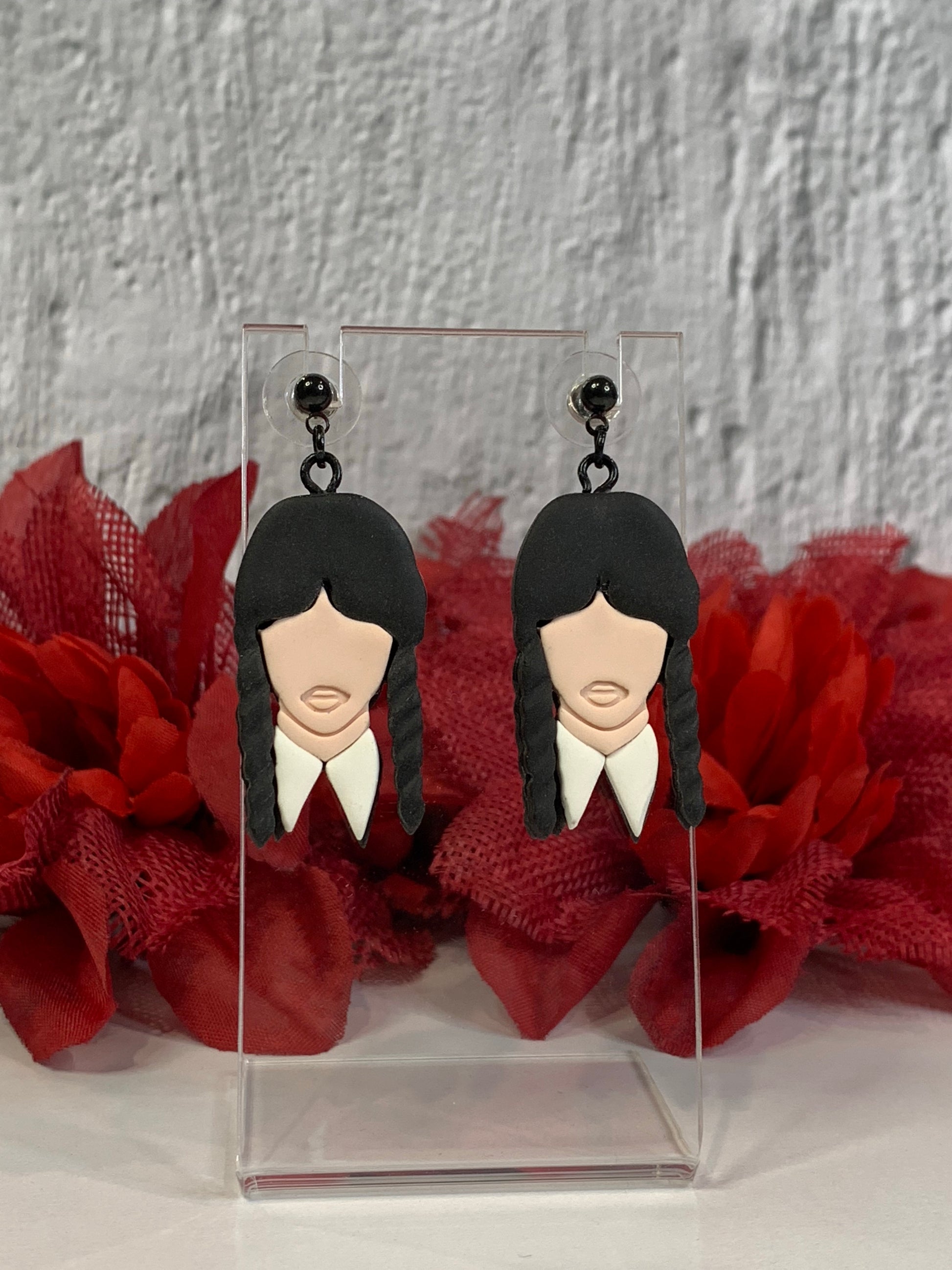 Handmade Classic Wednesday Addams earrings — lightweight polymer clay dangles that capture Wednesday’s iconic black braids and crisp white collar. Perfect for gothic jewelry lovers, Addams Family fans, or Nevermore Academy cosplay, these small-batch earrings bring spooky-chic style to everyday wear or Halloween costumes. Each pair is hand-sculpted, finished with durable black-plated stainless-steel findings, and designed to be comfortable for all-day wear.