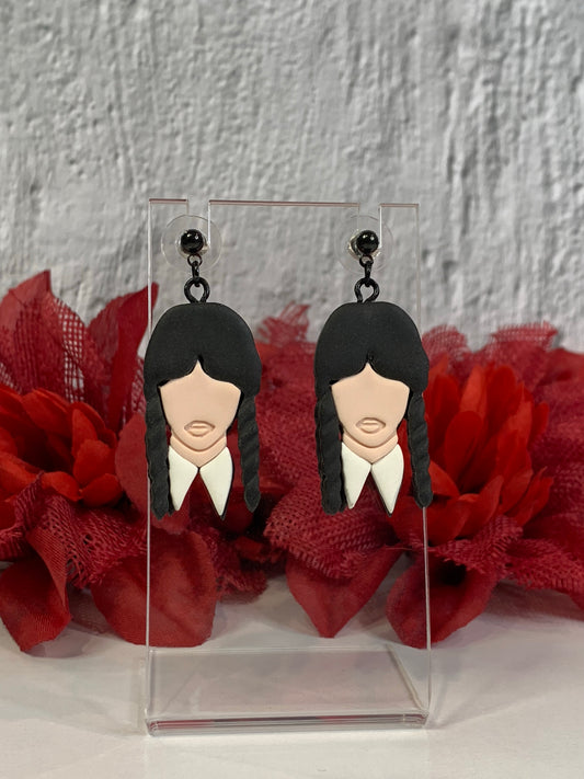 Handmade Classic Wednesday Addams earrings — lightweight polymer clay dangles that capture Wednesday’s iconic black braids and crisp white collar. Perfect for gothic jewelry lovers, Addams Family fans, or Nevermore Academy cosplay, these small-batch earrings bring spooky-chic style to everyday wear or Halloween costumes. Each pair is hand-sculpted, finished with durable black-plated stainless-steel findings, and designed to be comfortable for all-day wear.